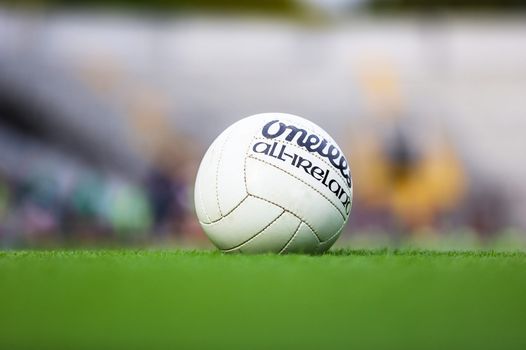 GAA football on a pitch with out-of-focus seats in background