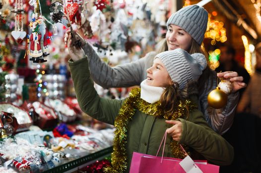girl with mother at Christmas markets looking at decorations