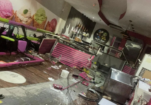 Interior of a gelato shop with smashed glass, furniture in disarray and other evidence of an accident