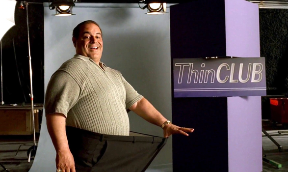 Vito from Sopranos holding out a pair of too-big trousers, with a sign reading Thin Club in the beackground