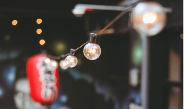 out of focus fairy lights and a red japanese lantern hanging in an outdoor terrace