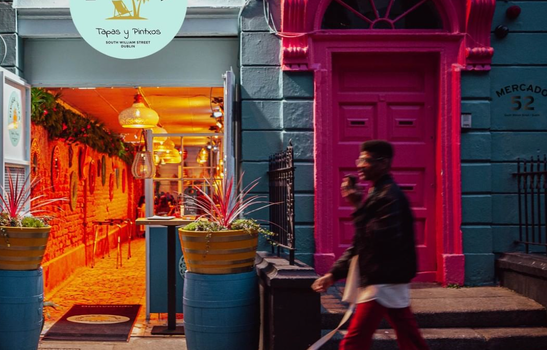 south william street at night, doors of a building open to show a tapas bar inside