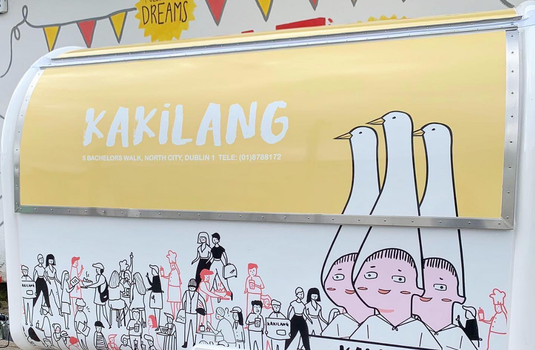 Kakilang food trailer with colourful illustrations on the walls and a yellow hatch