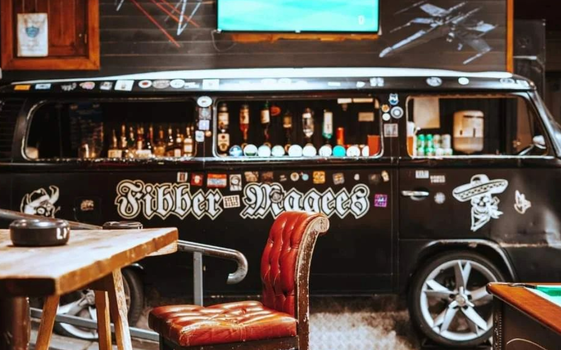 Black food truck with "Fibber Magees" written on the side, parked in a beer garden