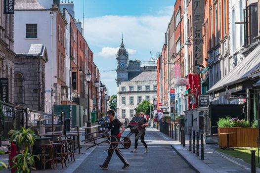 restaurant workers setting up outdoor tables and chairs on south william street