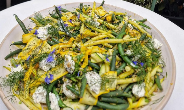 summer style salad on a plate with green beans, yogurt dressing and dill