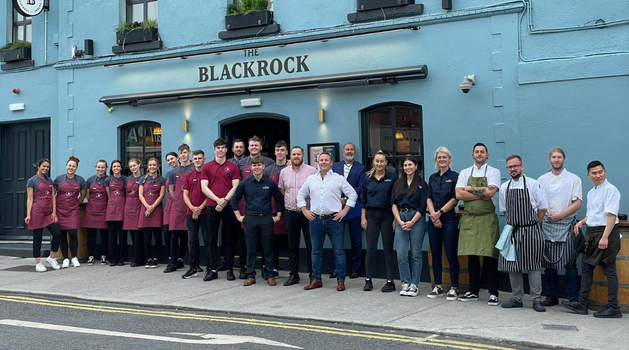 large group of waiters, bar staff and chefs standing outside a pub in Blackrock