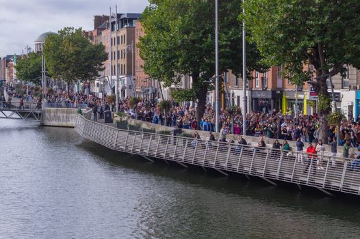 a protest in Dublin with thousands of people marching along the liffey