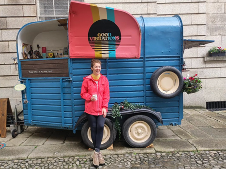 woman in a pink coat standing outside a horsebox cafe