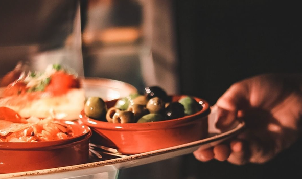 olives and other small plates waiting to be served on a pass in a cafe