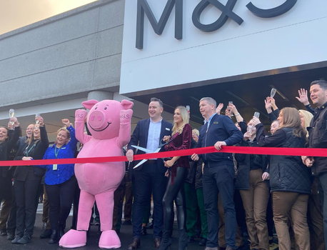 Percy Pig and M&S staff cutting a ribbon outside the opening of a new store