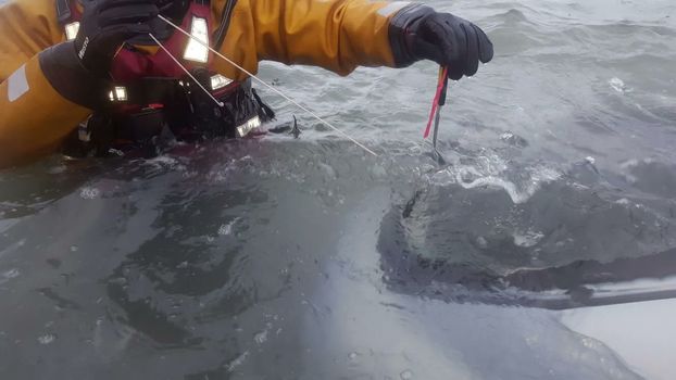 emergency rescue worker in protective gear in a frozen lake