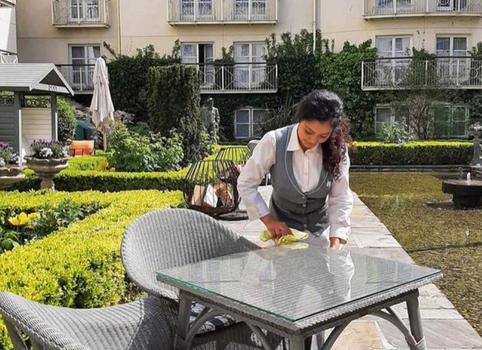 staff member at the merrion wiping an outdoor table