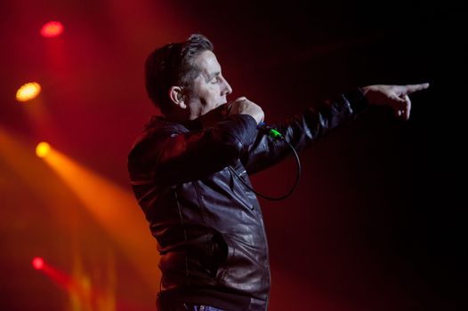 christy dignam on stage at a gig, pointing out to crowd