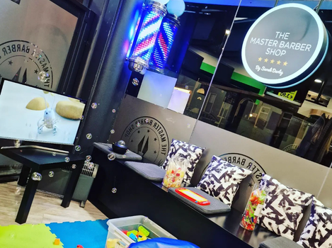 barbershop with a large tv screen and colourful playmats on the floor