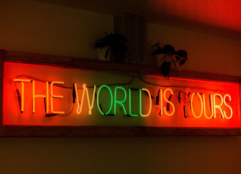Neon sign which reads "The World Is Yours" inside Variety Jones restaurant