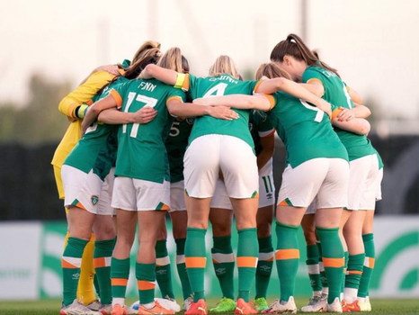 Irish women's football team in a huddle during a match