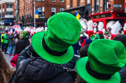 two people wearing leprechaun hats watching the paddy's day parade in dublin
